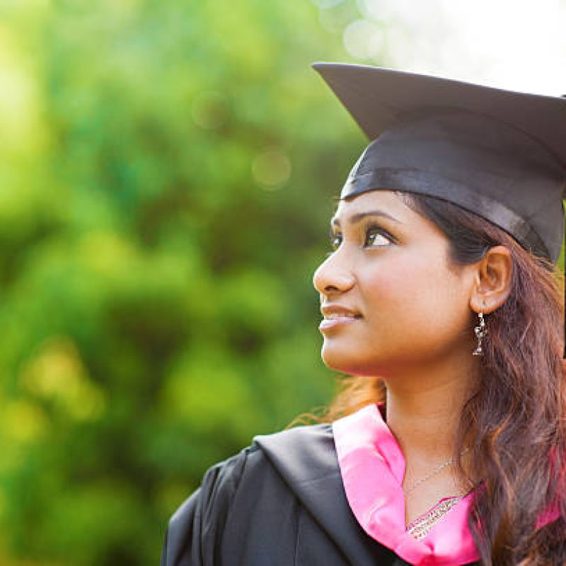 Smiling Young Asian Indian female student looking away with copy space Smiling Young Asian Indian female student looking away with copy space
